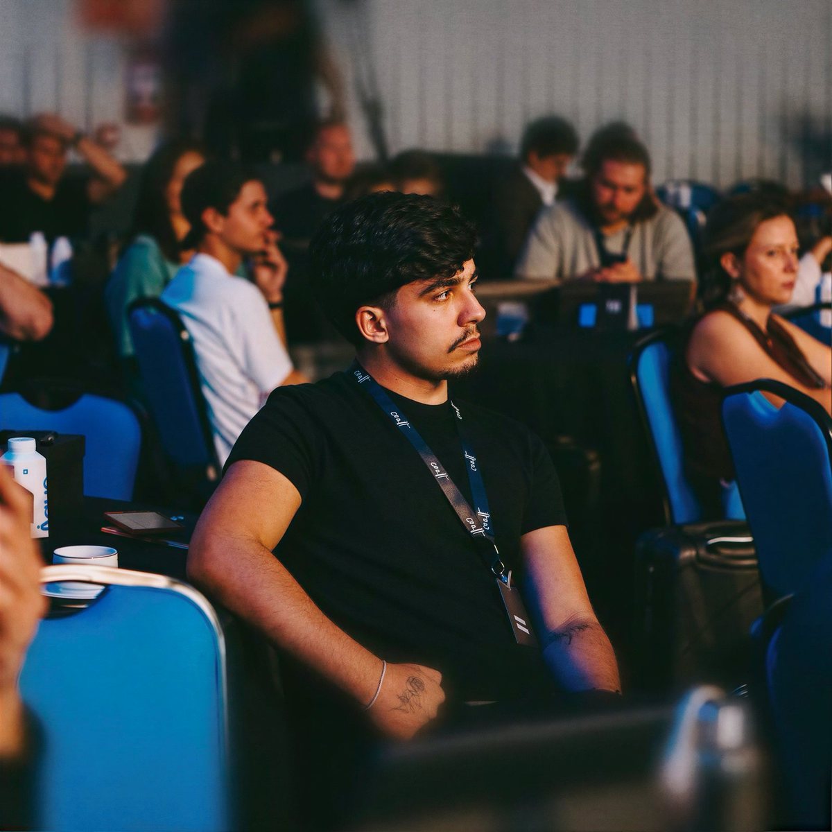 Mateus Ferreira, fundador e diretor criativo da NEXYO, sentado na plateia de um evento
